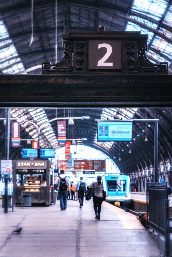 Buenos Aires, Argentina - August 29, 2019: Main train station in Retiro, with train arriving in the distance and passengres walking towards it. Buenos Aires, Argentina - August 29, 2019: Main train station in Retiro, with train arriving in the distance and passengres walking towards it