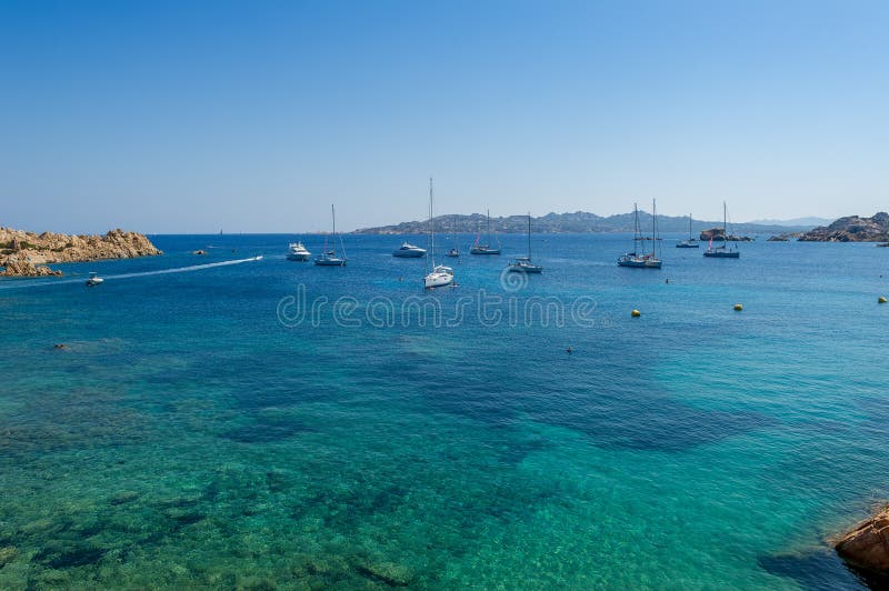 Baia Mediterranea con l'ancoraggio dell'acqua e della barca a vela del turchese fotografia stock Baia Mediterranea con l'ancoraggio dell'acqua e della barca a vela del turchese fotografia stock