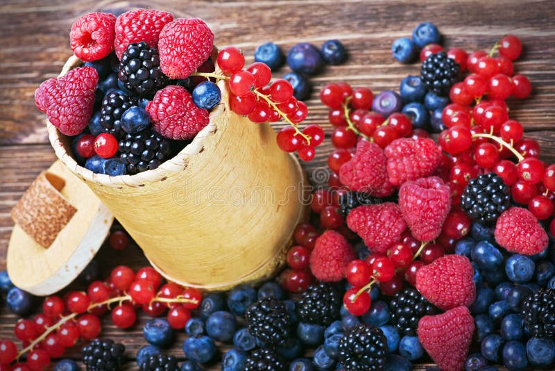 Assorted Fresh berries on a wooden table. Assorted Fresh berries on a wooden table