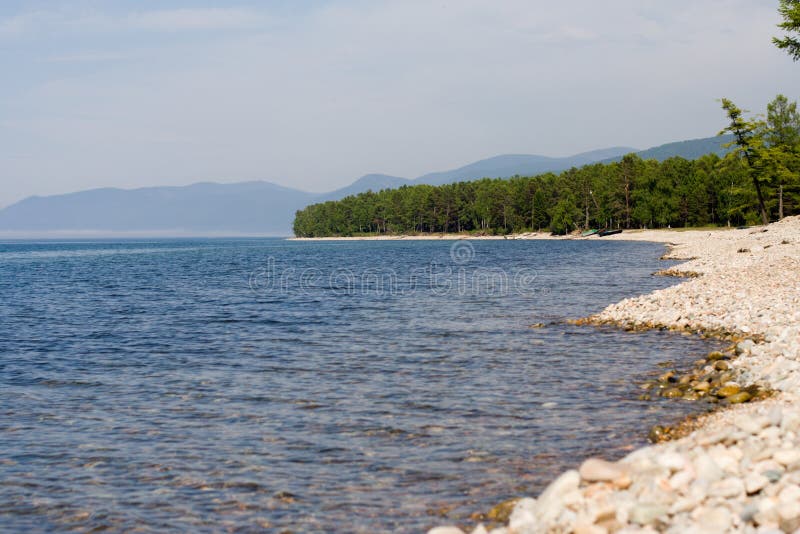 Baikal lakeside with cape Tolstoy on back plane (lake Baikal - first-rate reservoir of unadulterated sweet water, it contains about 1/4 of all world's reserve). Baikal lakeside with cape Tolstoy on back plane (lake Baikal - first-rate reservoir of unadulterated sweet water, it contains about 1/4 of all world's reserve)