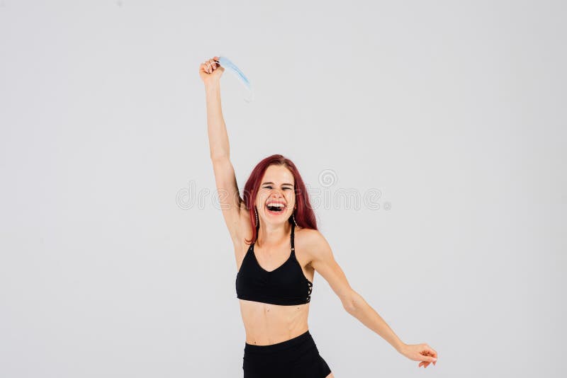 Female dancer in the styles of strip plastic and pole dance with face mask on light background. Female dancer in the styles of strip plastic and pole dance with face mask on light background