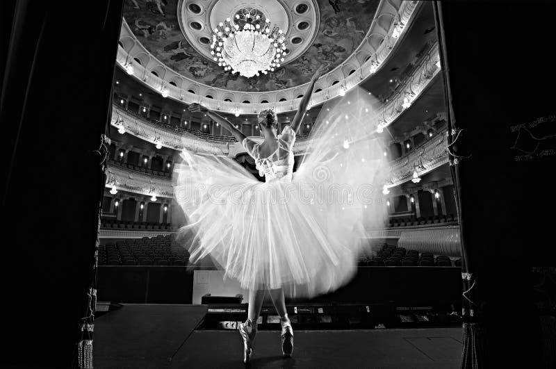 Bailarina mágica en el escenario del teatro con las manos levantadas en el aire.