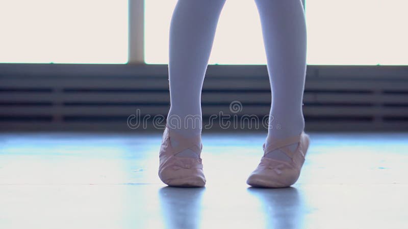 A bailarina pequena é contratada em uma escola do bailado A menina dança na escola Pés do fim da bailarina acima