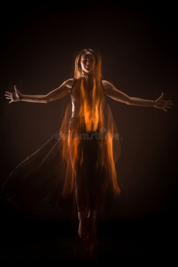 Bailarín hermoso joven en el baile beige del vestido en fondo negro imagenes de archivo Bailarín hermoso joven en el baile beige del vestido en fondo negro imagenes de archivo