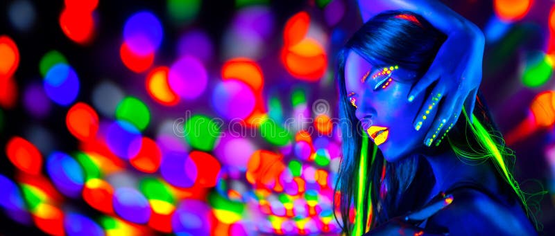 Baile atractivo de la muchacha en las luces de neón Mujer del modelo de moda con el maquillaje fluorescente que presenta en ULTRA