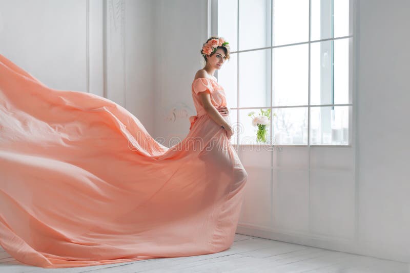 Baile de la mujer embarazada en el vuelo rosado del vestido de noche en el viento Tela que agita, tiro de la moda imagenes de archivo Baile de la mujer embarazada en el vuelo rosado del vestido de noche en el viento Tela que agita, tiro de la moda imagenes de archivo