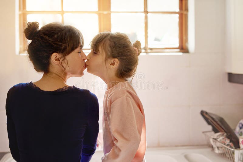 Baiser collant et mère avec enfant dans la cuisine pour le ménage ou le nettoyage ensemble avec l'apprentissage. joyeux, mignonne image stock