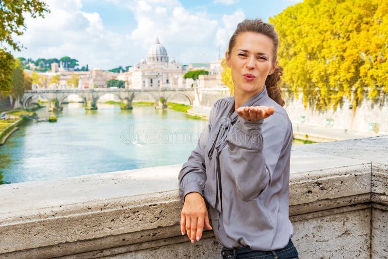 Young woman blowing kiss from ponte umberto I with view on basilica di san pietro. Young woman blowing kiss from ponte umberto I with view on basilica di san pietro