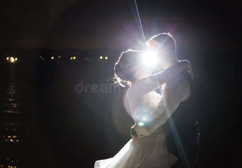 Baisers rétro-éclairés de couples de mariage de nuit photographie stock libre de droits