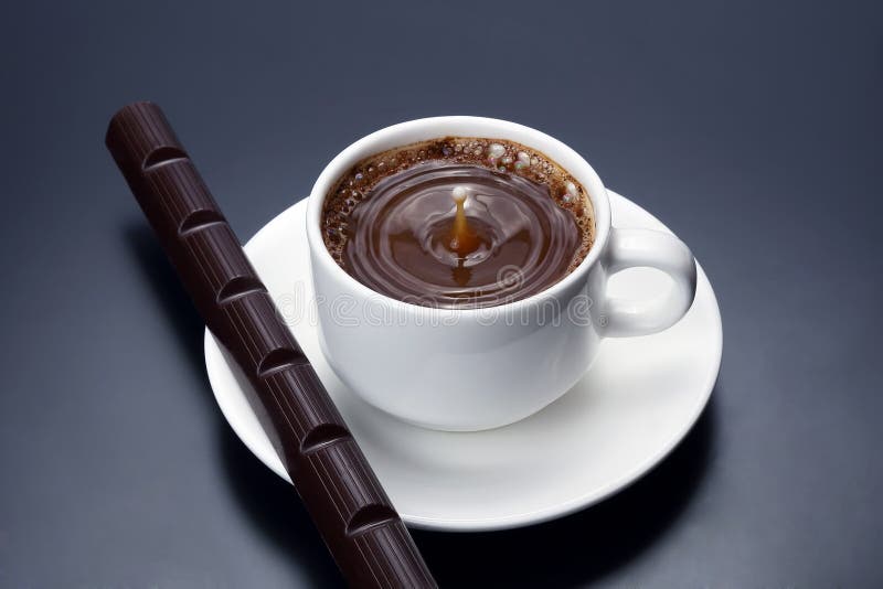 Baisse de lait tombant dans une tasse blanche avec du café noir image libre de droits Baisse de lait tombant dans une tasse blanche avec du café noir image libre de droits