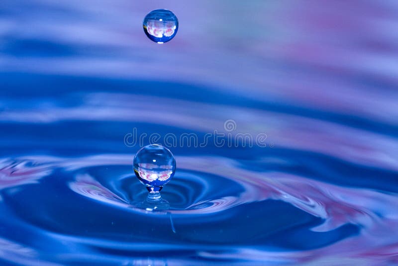 Double drops of water blue in color with hints of pink and flower reflections. Double drops of water blue in color with hints of pink and flower reflections
