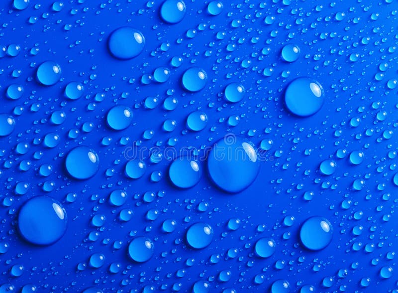 Multiple water drops of different sizes on a blue surface. Multiple water drops of different sizes on a blue surface