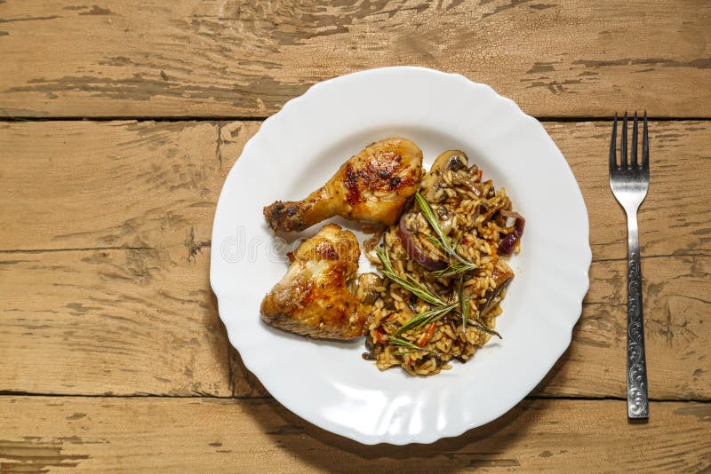 Baked Chicken Drumsticks and Wings Marinated with Risotto in a Plate on