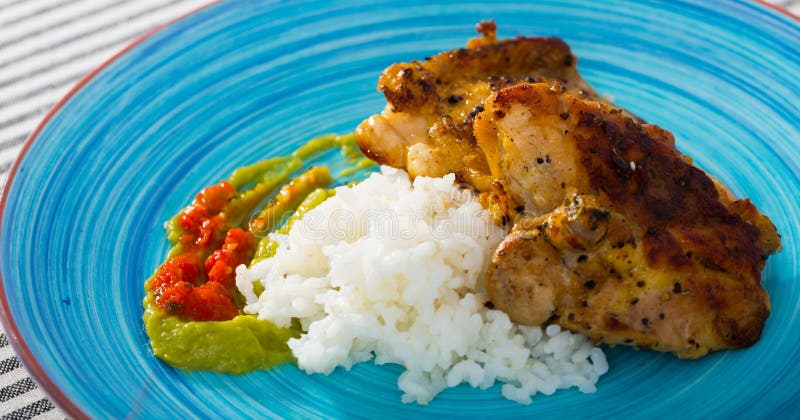 Baked Chicken Thighs and Rice with Sauces Stock Photo - Image of green
