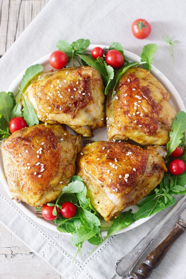 Baked Chicken Thighs with Garnish of Arugula and Tomatoes. Rustic Style