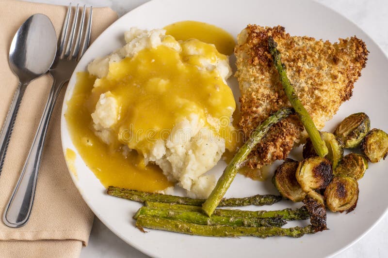 Baked cod served with roasted vegetables stock photos