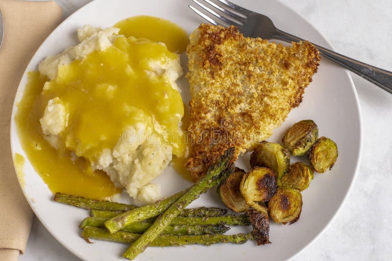 Baked cod served with roasted vegetables stock photos