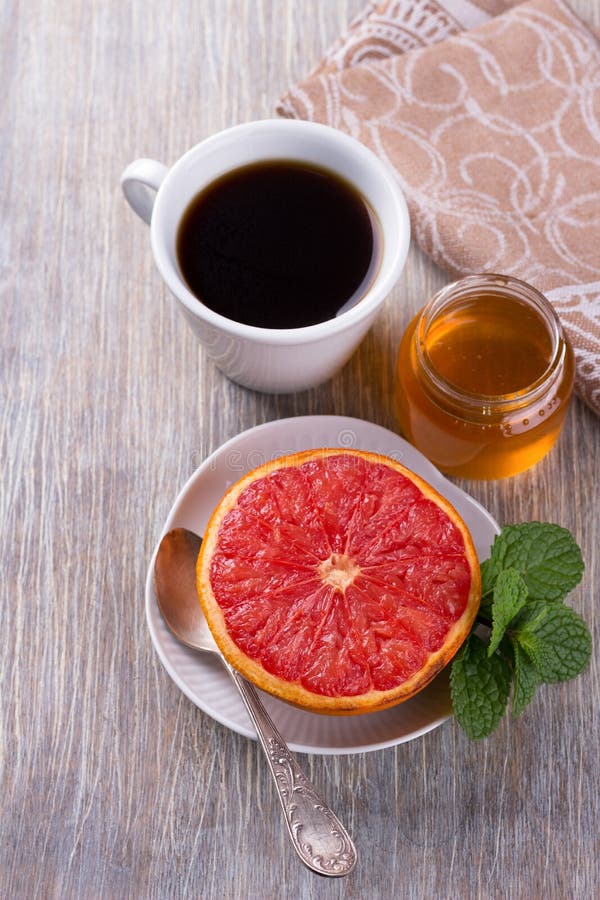 Baked Grapefruit with Honey and a Cup of Black Coffee Stock Photo