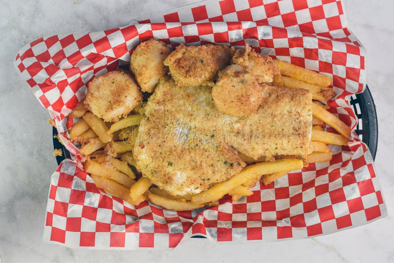 Baked haddock served with scallops and fries stock images
