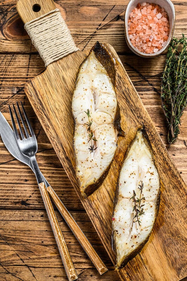 Baked halibut fish steak. wooden background. Top view royalty free stock photography