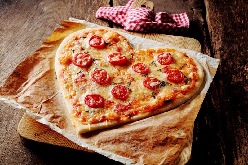 Baked heart-shaped pizza topped with tomato slices