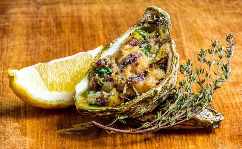 Baked Oyster Shell With Cheese, Served Greens And Lemon Stock Photo