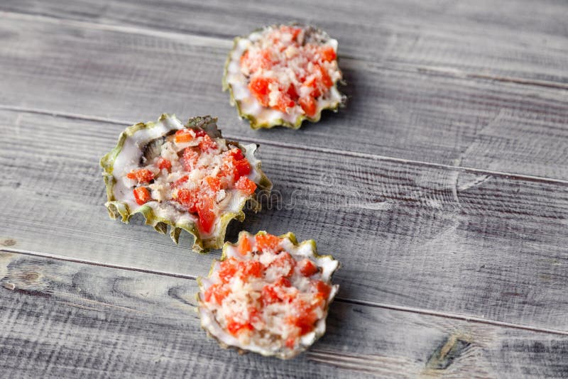 Baked oyster stuffed with tomato, parmesan and spices, hot appetizer in a seafood restaurant. Concept of the seaside grill bar, royalty free stock photos Baked oyster stuffed with tomato, parmesan and spices, hot appetizer in a seafood restaurant. Concept of the seaside grill bar, royalty free stock photos