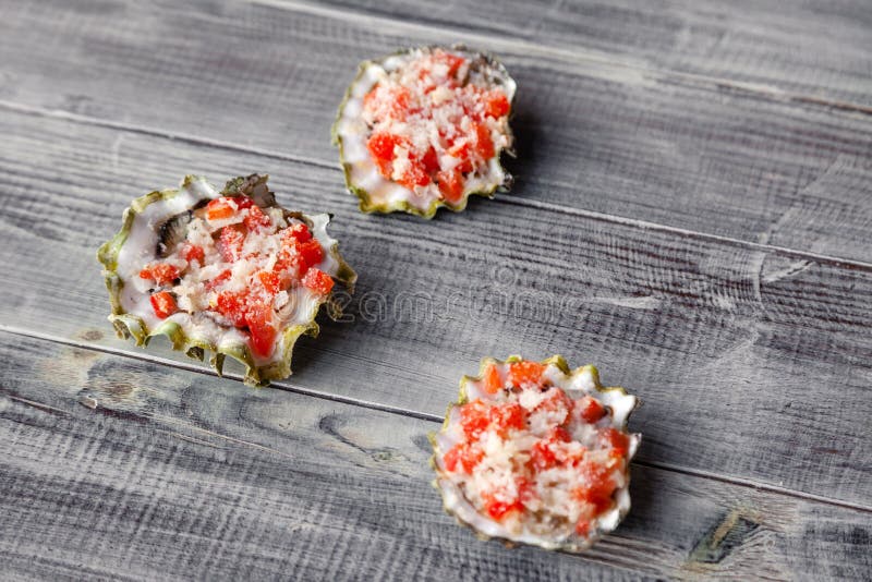 Baked oyster stuffed with tomato, parmesan and spices, hot appetizer in a seafood restaurant. Concept of the seaside grill bar, royalty free stock images Baked oyster stuffed with tomato, parmesan and spices, hot appetizer in a seafood restaurant. Concept of the seaside grill bar, royalty free stock images