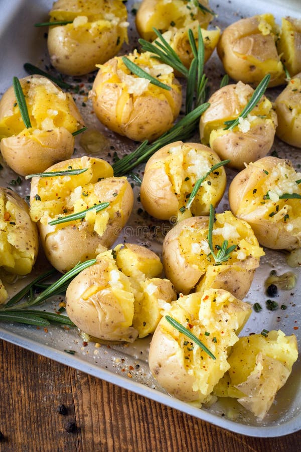 Baked potatoes with rosemary, garlic and pepper. Roasted potatoes with rosemary, pepper and pink sea salt in tray, close up. SIde dish for holiday family dinner royalty free stock photo Baked potatoes with rosemary, garlic and pepper. Roasted potatoes with rosemary, pepper and pink sea salt in tray, close up. SIde dish for holiday family dinner royalty free stock photo
