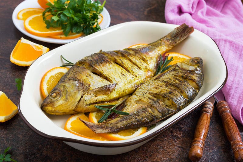 Baked Roach Fish with Vegetables and Oranges in a Ceramic Bowl. Diet