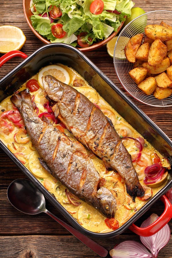 Baked Trout with Lemon Sauce and Vegetables in a Pan Stock Image