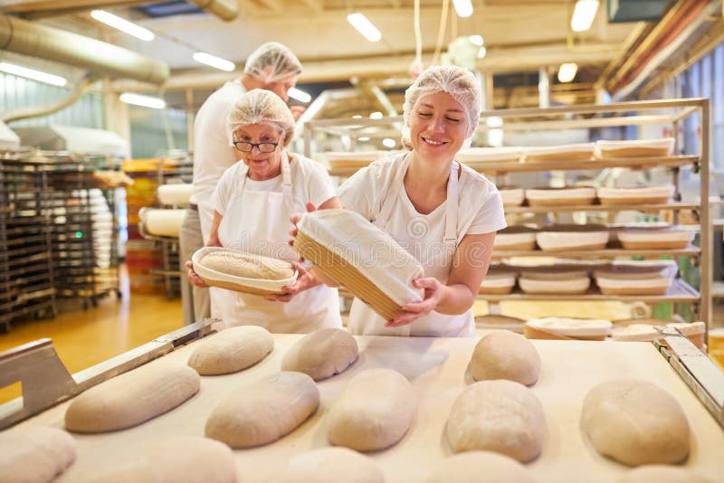 Baker As an Apprentice and Older Colleague Baking Bread Stock Photo