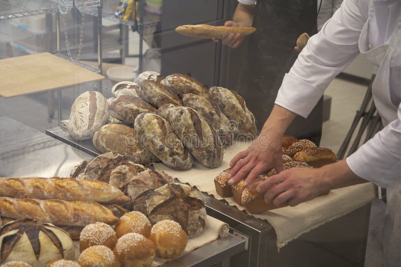 Baker in a Bakery with Bread and Oven in the Background Stock Photo