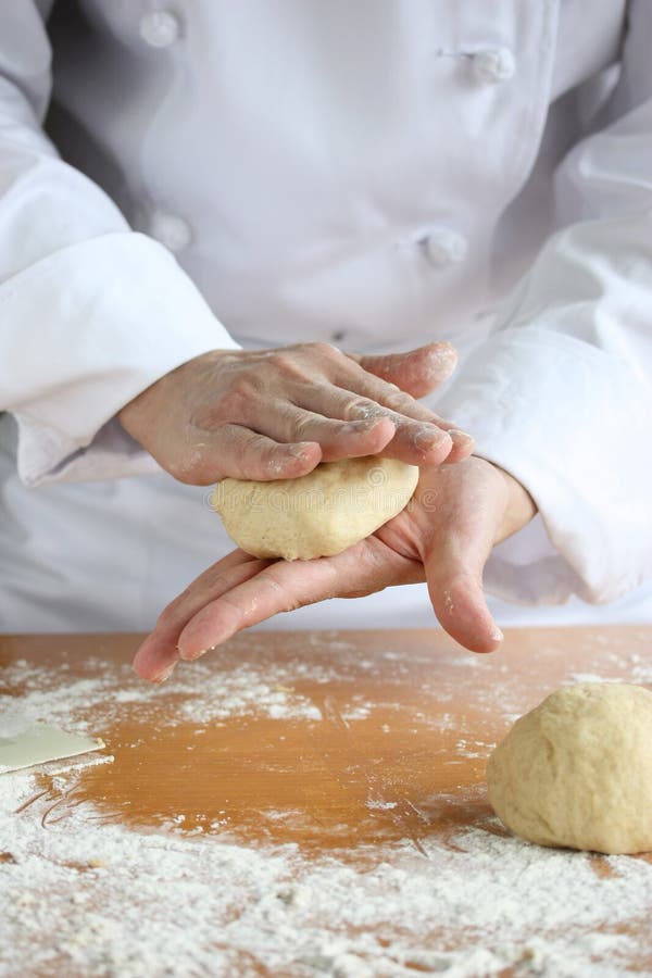 Baker effectuant le pain, malaxant une pâte