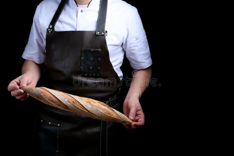 Baker holds baguette isolated on black background stock images Baker holds baguette isolated on black background stock images