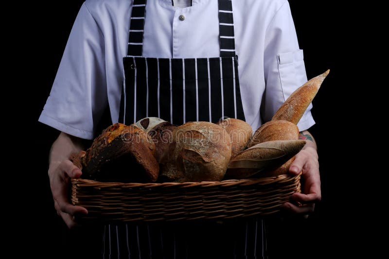 Baker holds basket of bread isolated on black background royalty free stock photos Baker holds basket of bread isolated on black background royalty free stock photos
