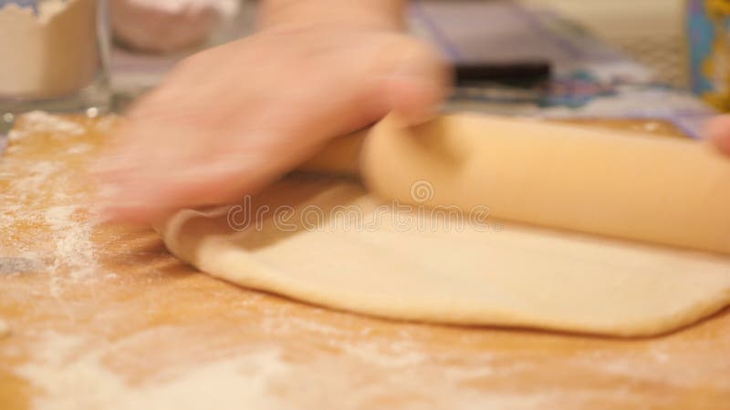 Baker kneading dough in flour on table