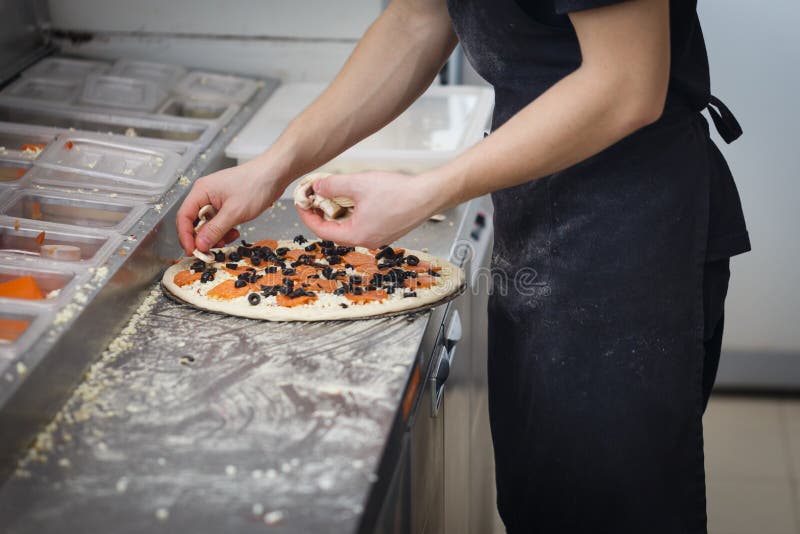Baker Lays Tomatoes and Cheese on the Pizza Crust in a Fast Food