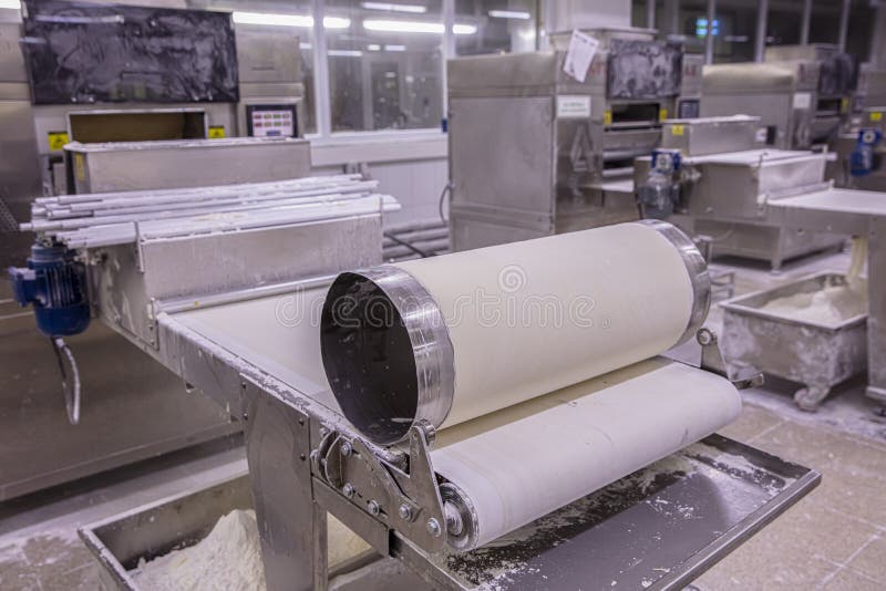 Baker Making Dough for Pastry on Dough Sheeter. Dough Rolling Machine