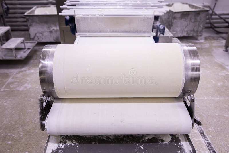 Baker Making Dough for Pastry on Dough Sheeter. Dough Rolling Machine