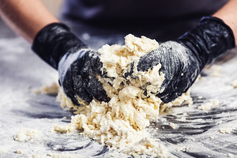 Baker`s Hands in Black Gloves Knead the Dough Stock Image Image of