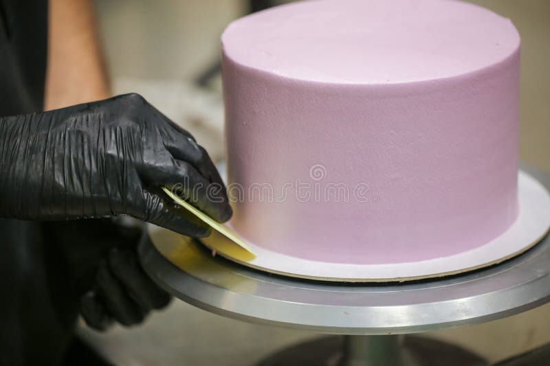 Baker Wearing Protective Gloves Decorating a Beautiful Purple Cake in ...