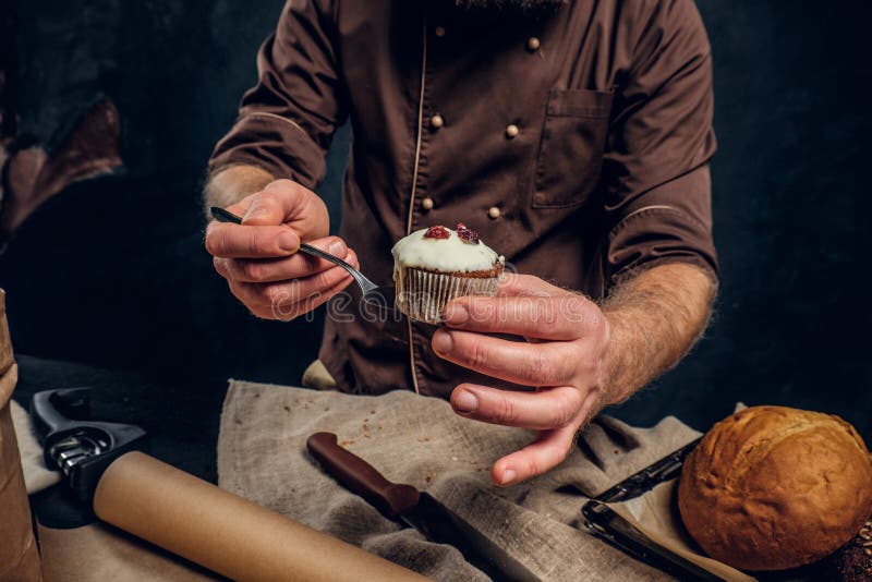 A Baker Wearing A Uniform Holding Tray With Freshly Prepared Products