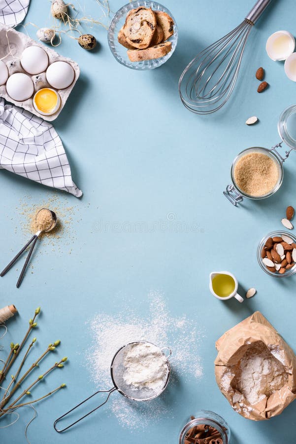 Bakery background frame. Fresh cooking ingredients - egg, flour, sugar, butter, nuts over blue background. Spring cooking theme. stock photos