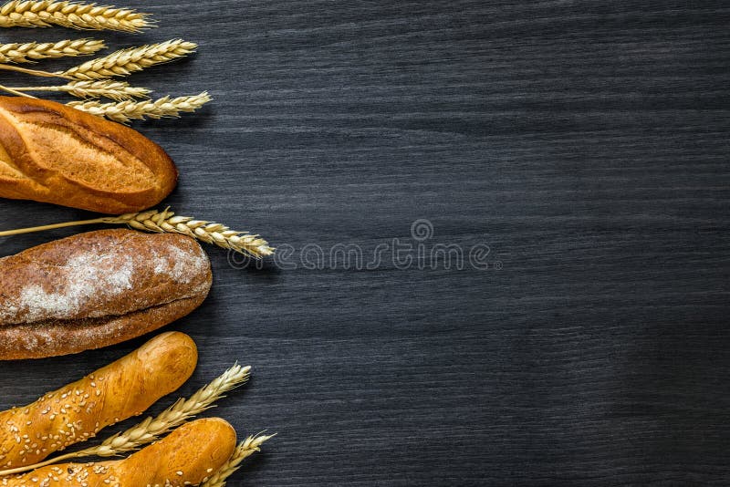 Bakery Background Top View. Crusty Buns and Loaves of Bread on Dark
