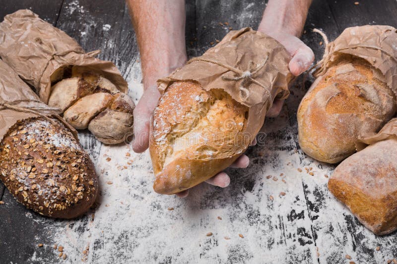 Bakery concept background. Hands hold bread loaf