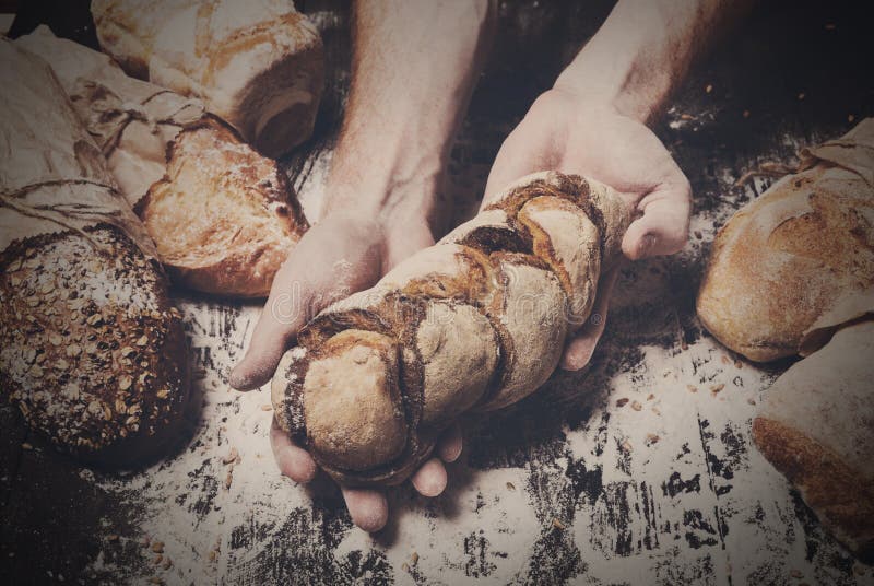Bakery concept background. Hands hold bread loaf