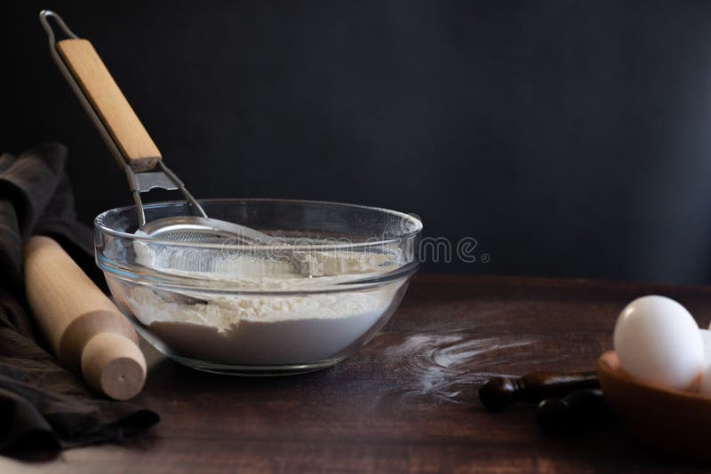 Bakery Items Flour and Eggs on Dark Background, Healthy Basic Baking Ingredients Stock Photo