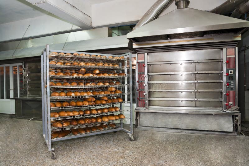 Wired rack filled with fresh baked bread by the bakery oven.