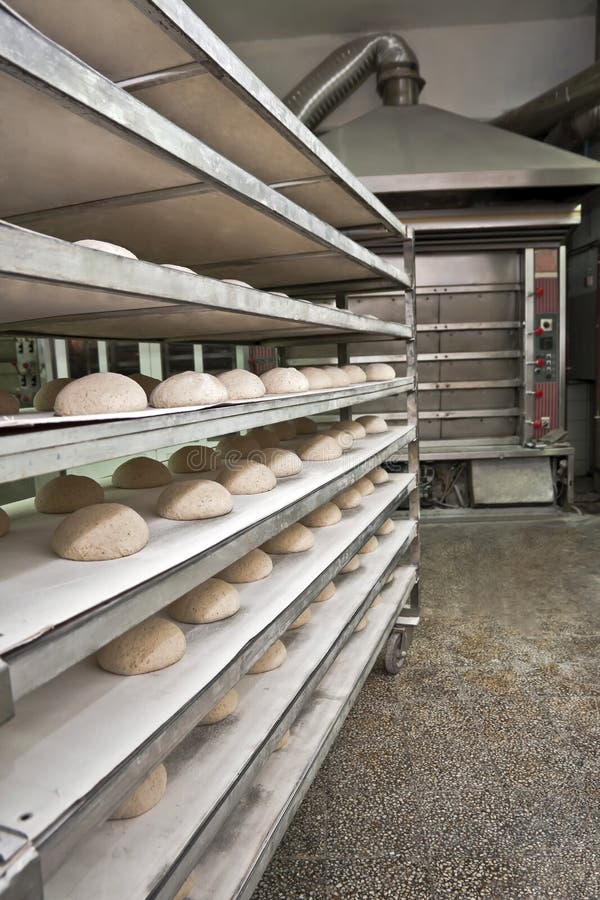 Wired rack filled with fresh uncooked bread prepared for stacking into the bakery oven.